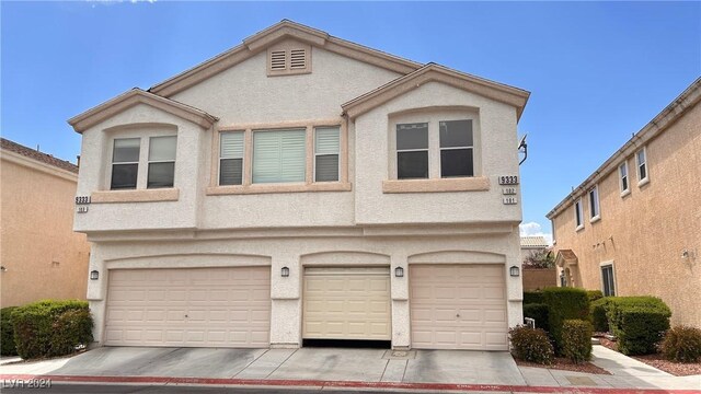 multi unit property with a garage and stucco siding