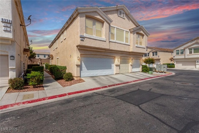 9333 Leaping Deer Pl Unit 102, Las Vegas, NV 89178 - view of property featuring a garage, stucco siding, and concrete driveway