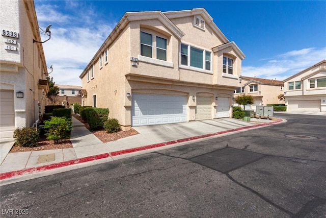 9333 Leaping Deer Pl Unit 102, Las Vegas, NV 89178 - view of property featuring an attached garage, stucco siding, and concrete driveway