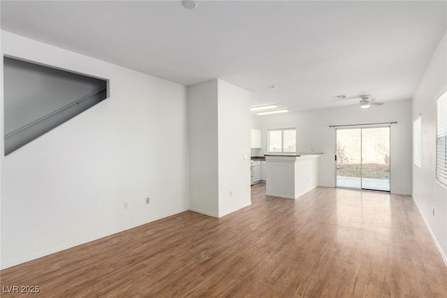9333 Leaping Deer Pl Unit 102, Las Vegas, NV 89178 - unfurnished living room featuring light wood-style flooring, ceiling fan, and baseboards