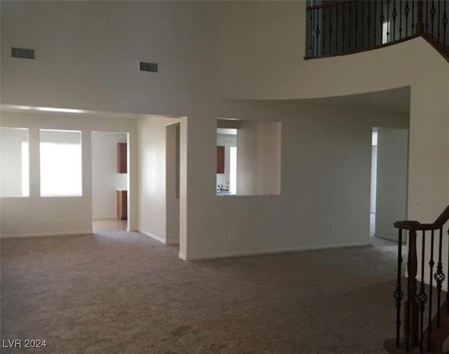 carpeted empty room with a high ceiling