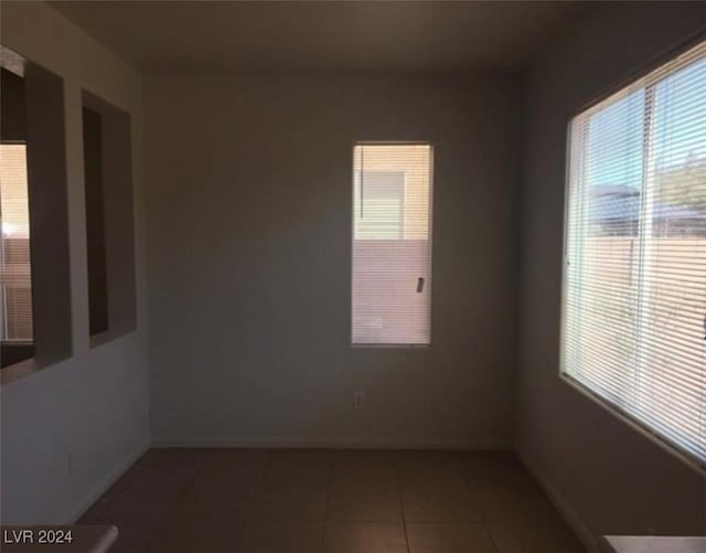 unfurnished room featuring a healthy amount of sunlight and tile patterned flooring