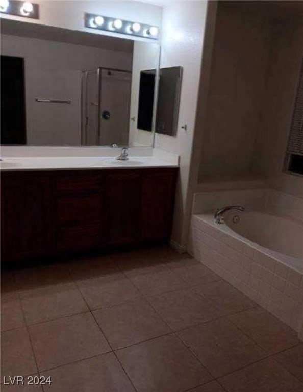 bathroom featuring vanity, a washtub, and tile patterned flooring