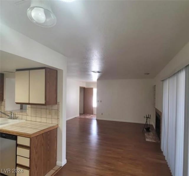 unfurnished living room with sink and dark wood-type flooring