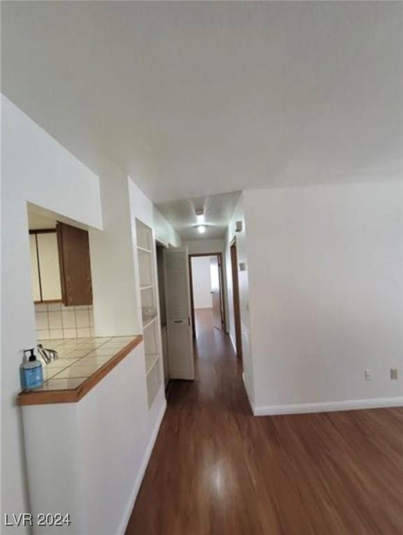 corridor featuring dark hardwood / wood-style floors and built in features