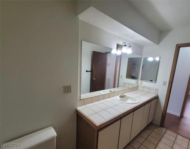 bathroom featuring toilet, vanity, and tile patterned floors