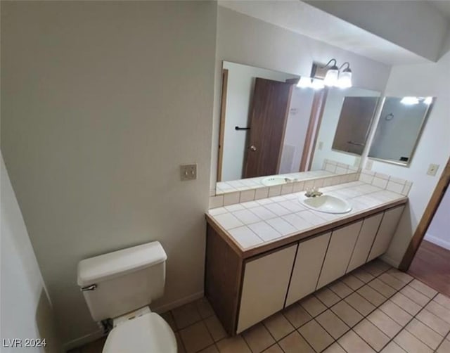 bathroom featuring tile patterned floors, vanity, and toilet