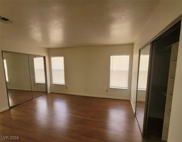 unfurnished bedroom featuring dark hardwood / wood-style floors and a textured ceiling