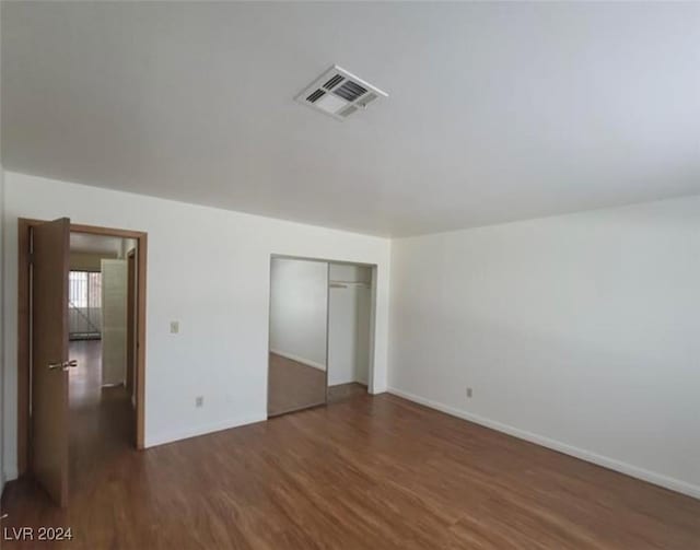 unfurnished bedroom featuring dark wood-type flooring and a closet