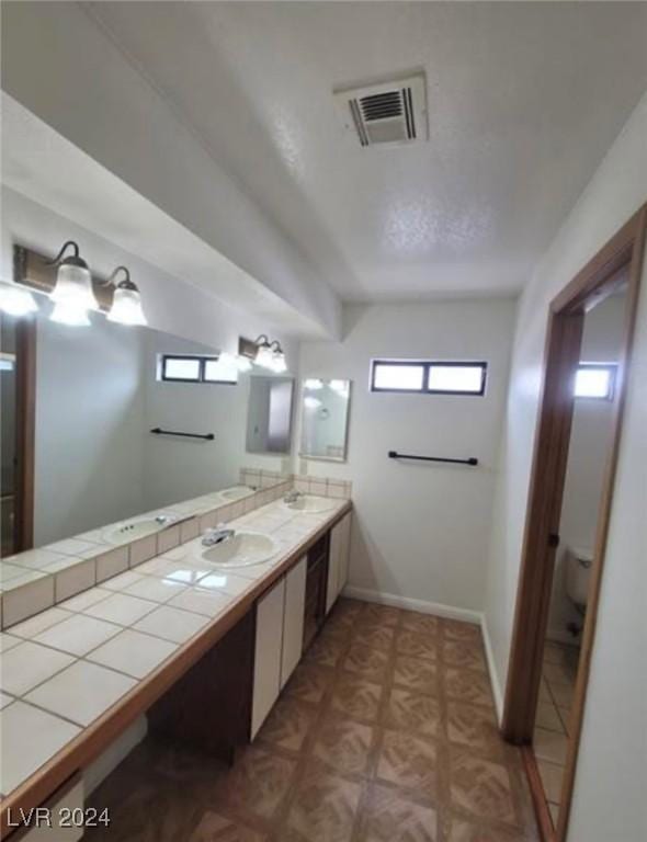 bathroom featuring vanity, toilet, and parquet floors