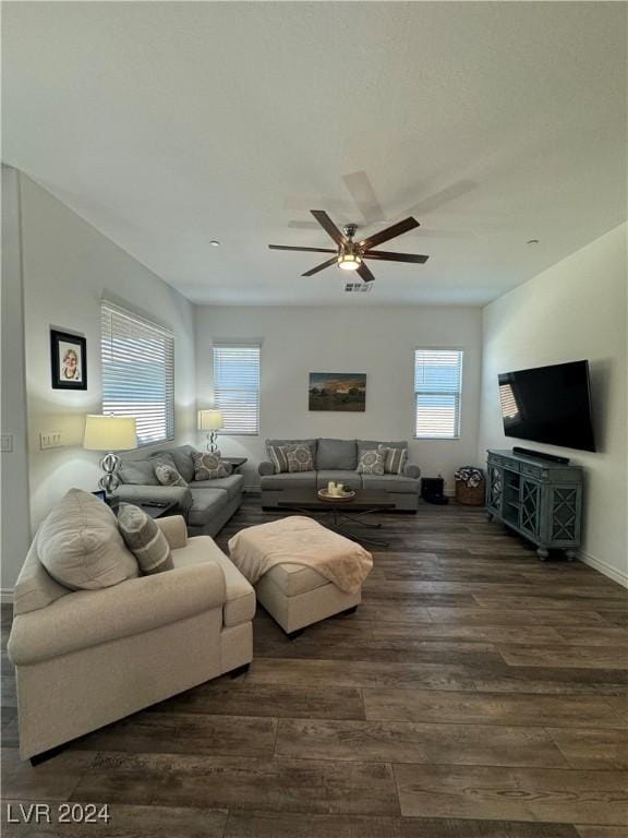 living room featuring dark wood finished floors, a ceiling fan, and baseboards