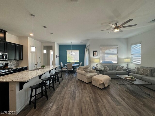 living room with sink, dark hardwood / wood-style flooring, and ceiling fan with notable chandelier