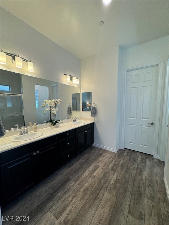 bathroom with dual bowl vanity and hardwood / wood-style floors