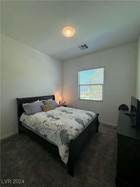 bedroom featuring dark colored carpet, visible vents, and baseboards