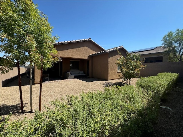 exterior space featuring a tiled roof, a patio, fence, and stucco siding