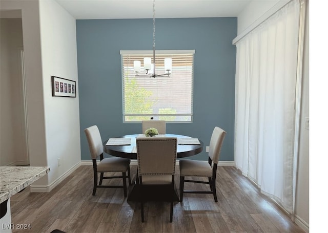 dining space with a chandelier, wood finished floors, and baseboards