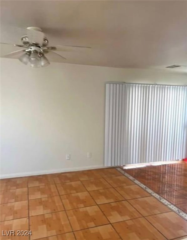 unfurnished room with light tile patterned floors and ceiling fan