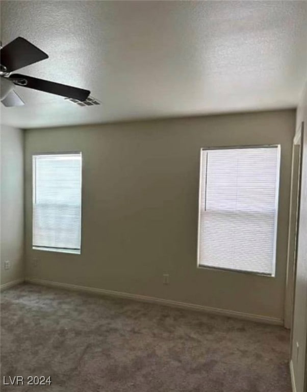 spare room featuring ceiling fan and carpet