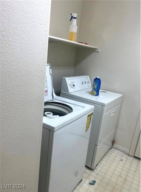 washroom with light tile patterned floors and washer and clothes dryer