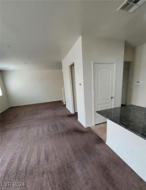 unfurnished room featuring dark carpet