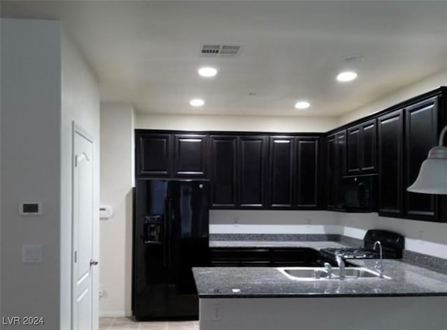 kitchen featuring black appliances, sink, kitchen peninsula, and dark stone counters