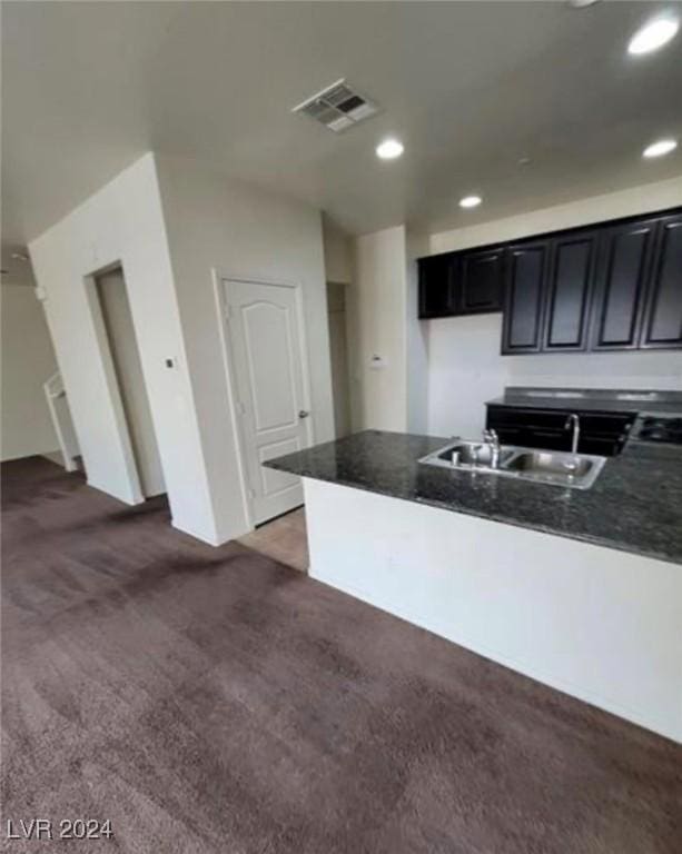 kitchen featuring dark colored carpet, sink, and gas cooktop