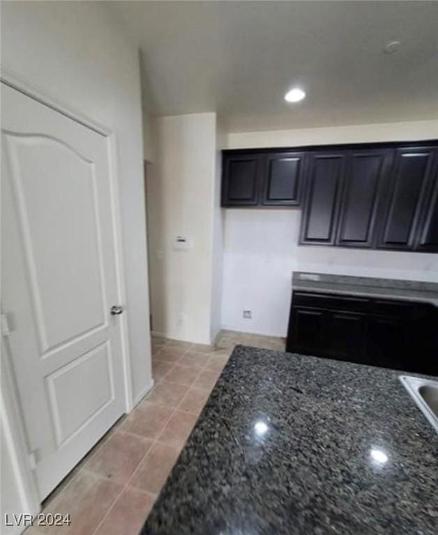 kitchen featuring light tile patterned floors and dark stone countertops