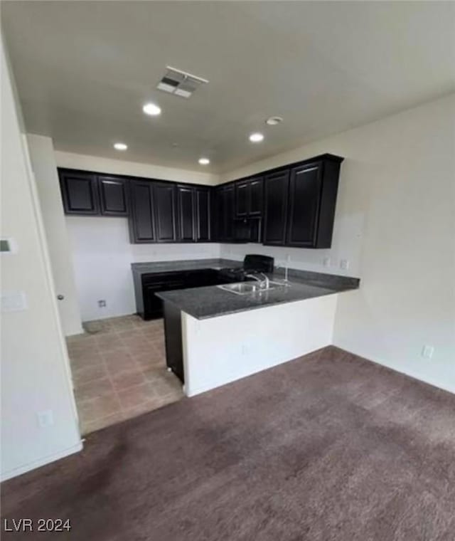 kitchen with light carpet, sink, and kitchen peninsula