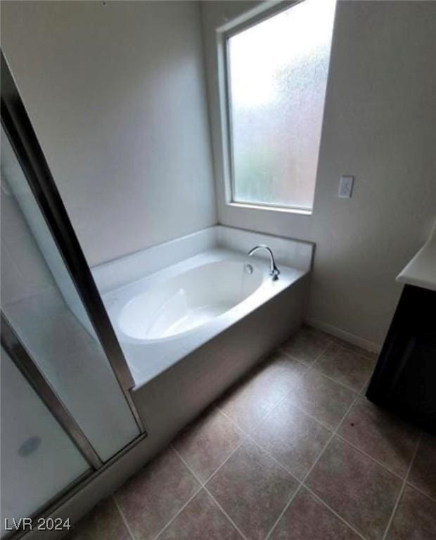 bathroom with independent shower and bath and tile patterned flooring