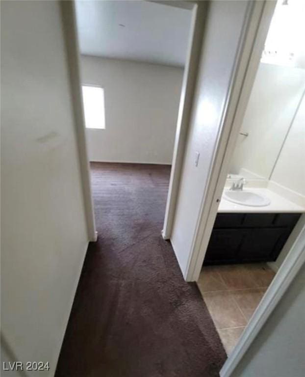 corridor with light colored carpet and sink