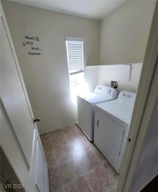 clothes washing area featuring light tile patterned flooring and washer and dryer