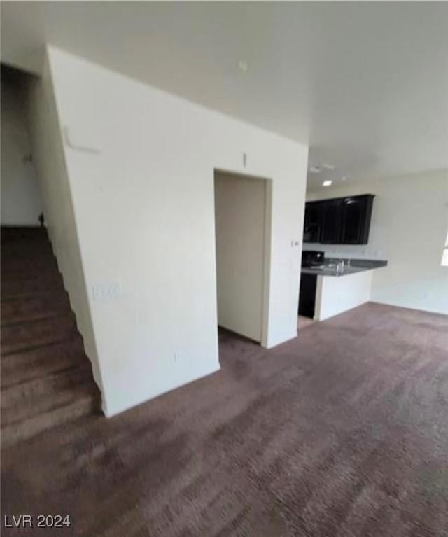 unfurnished living room featuring dark carpet