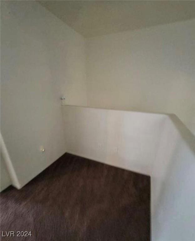 empty room with dark colored carpet