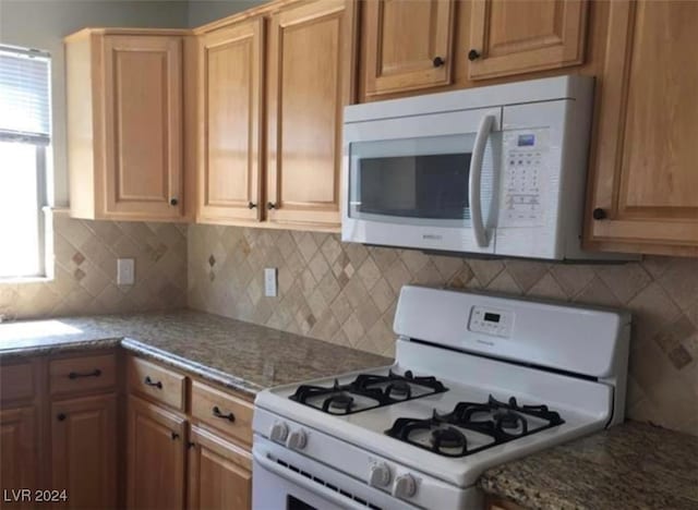 kitchen featuring decorative backsplash and white appliances