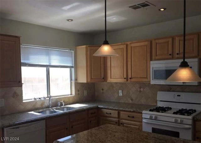 kitchen with backsplash, pendant lighting, sink, and white appliances