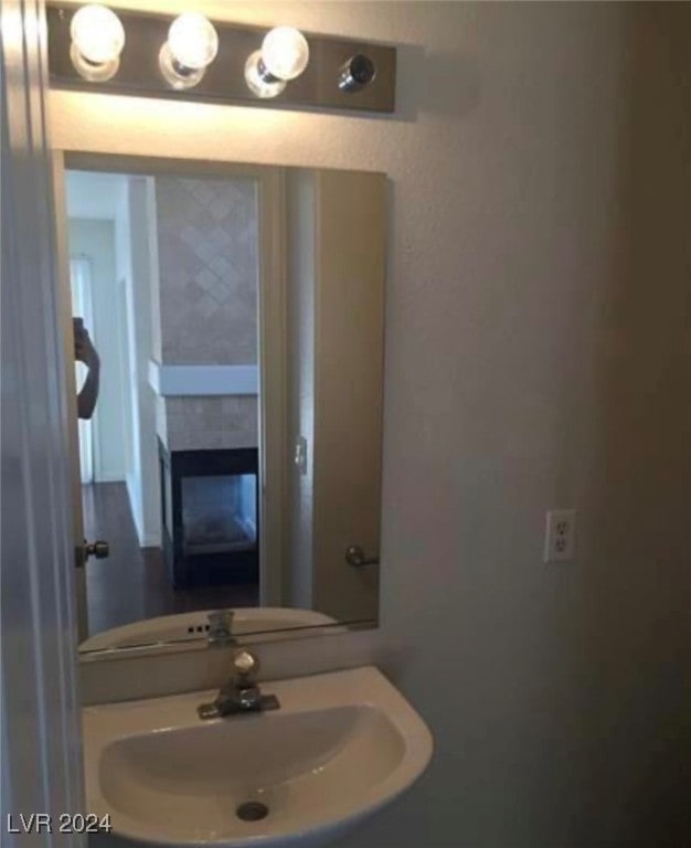 bathroom with a tile fireplace and sink