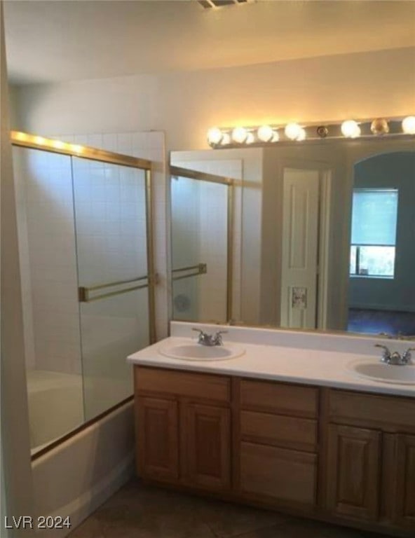 bathroom with enclosed tub / shower combo and dual bowl vanity