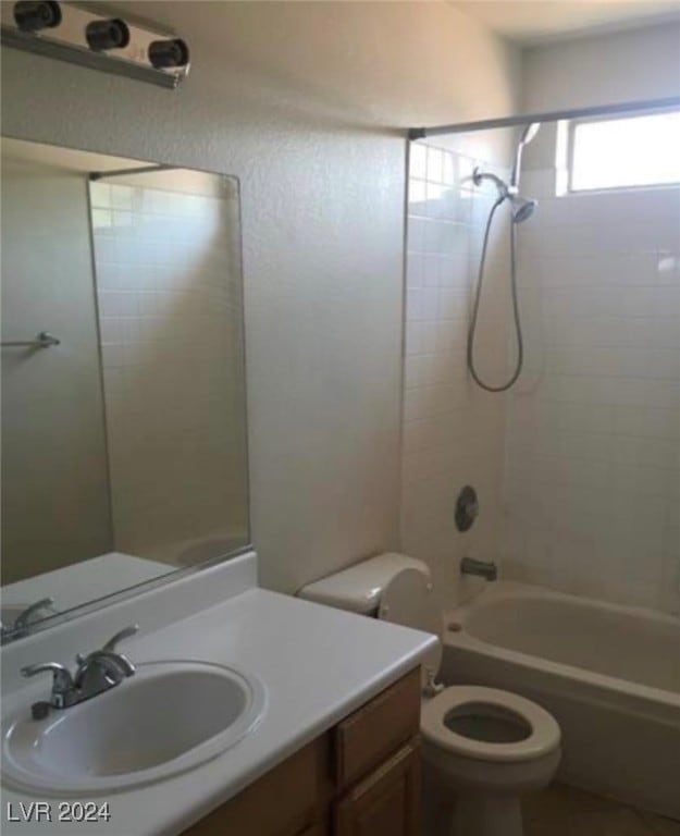 full bathroom with toilet, vanity, and tiled shower / bath