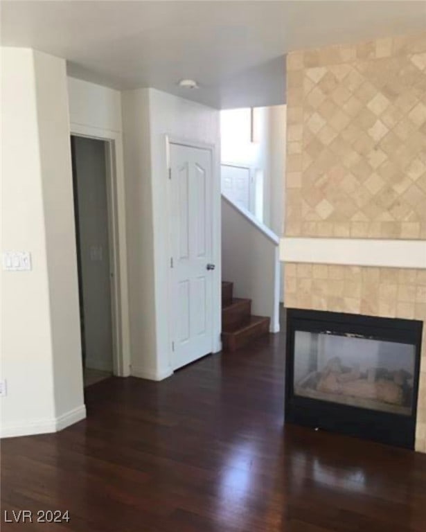 unfurnished living room with hardwood / wood-style floors and a tile fireplace