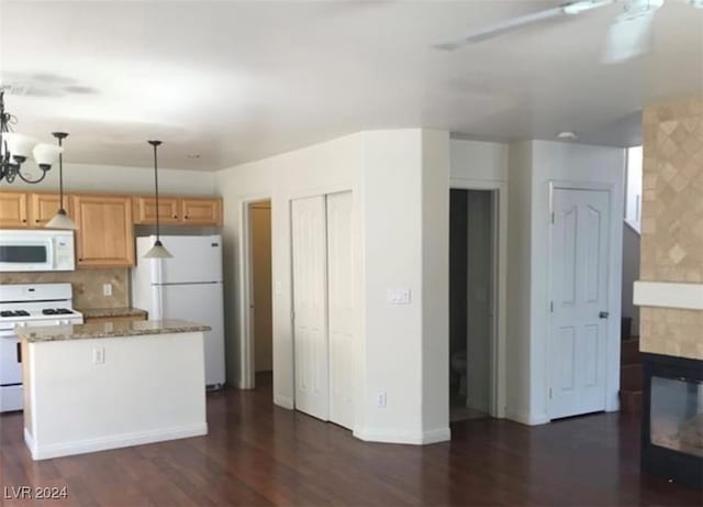 kitchen featuring white appliances, dark hardwood / wood-style floors, light stone countertops, a notable chandelier, and backsplash