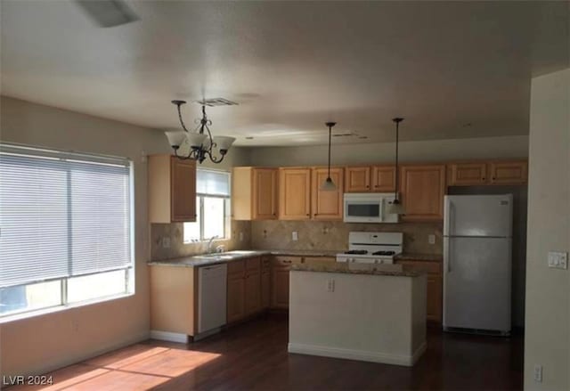 kitchen featuring white appliances, an inviting chandelier, backsplash, hardwood / wood-style flooring, and a kitchen island