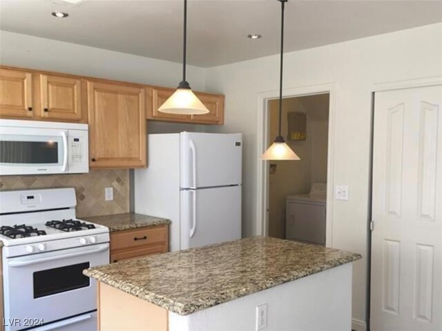 kitchen with decorative backsplash, washer / dryer, stone countertops, decorative light fixtures, and white appliances