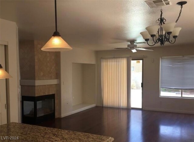 unfurnished living room with wood-type flooring, a chandelier, and a multi sided fireplace