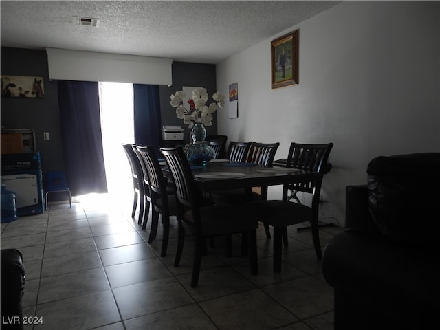 dining area with a textured ceiling and tile patterned floors