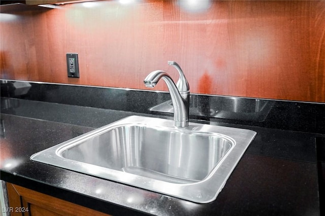 kitchen view of a sink, dark countertops, and brown cabinets