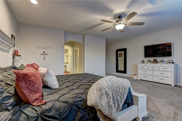 carpeted bedroom with ceiling fan and ensuite bath