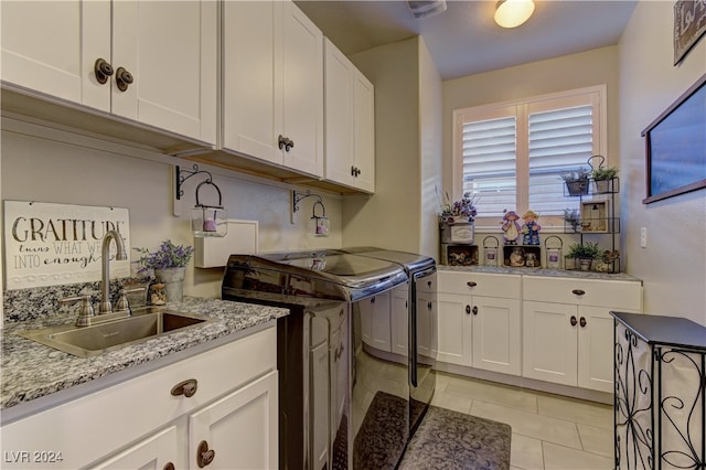 laundry room with independent washer and dryer, light tile patterned floors, sink, and cabinets