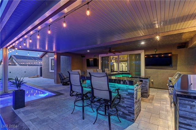 view of patio with exterior bar and ceiling fan