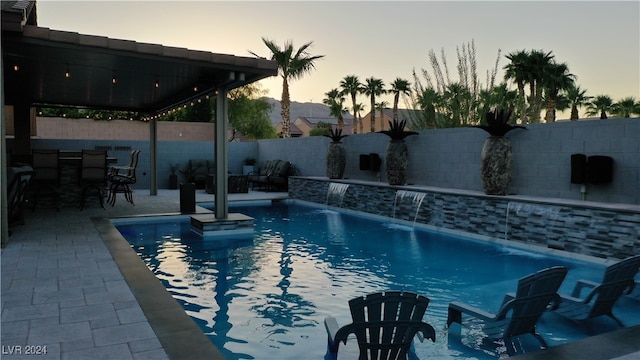 pool at dusk with pool water feature