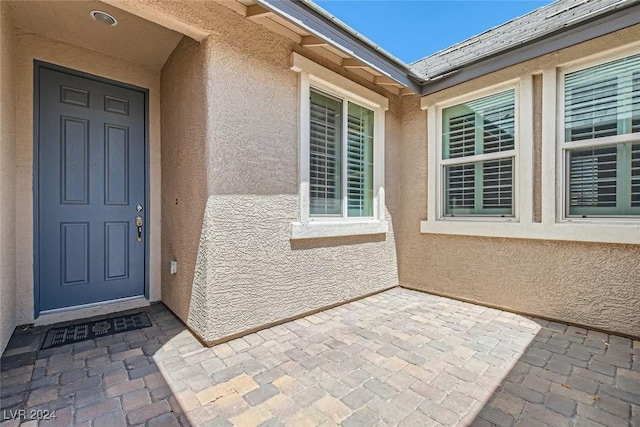 view of exterior entry featuring a patio area